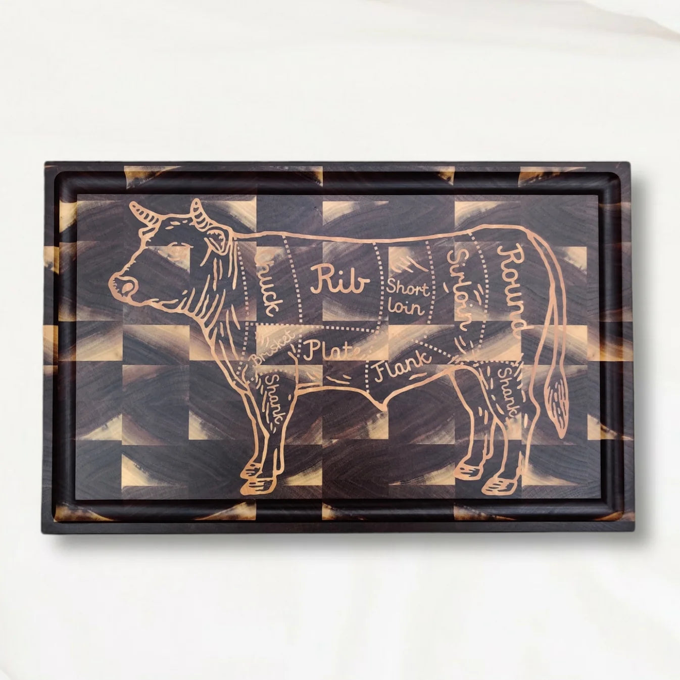 Wooden cutting board with a maple inlay of a cow cut into a walnut board