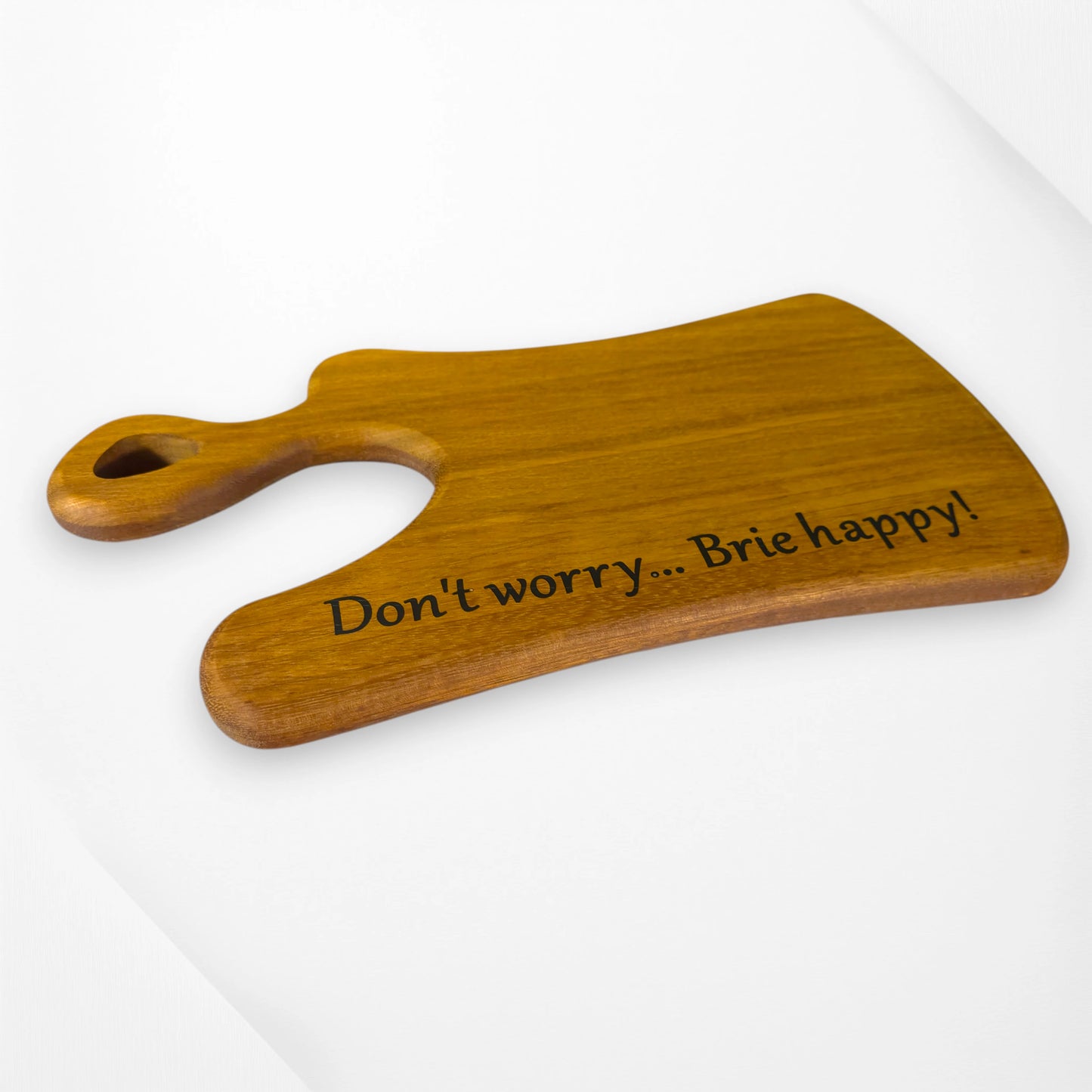 Angled view Indulge in a smile every snack time with our handcrafted cheese board, engraved with “Don’t worry… Brie happy!” Made from premium hardwood, it’s the perfect quirky gift for cheese lovers and entertainers. Personalisation available—add a playful touch to your kitchen or dining table