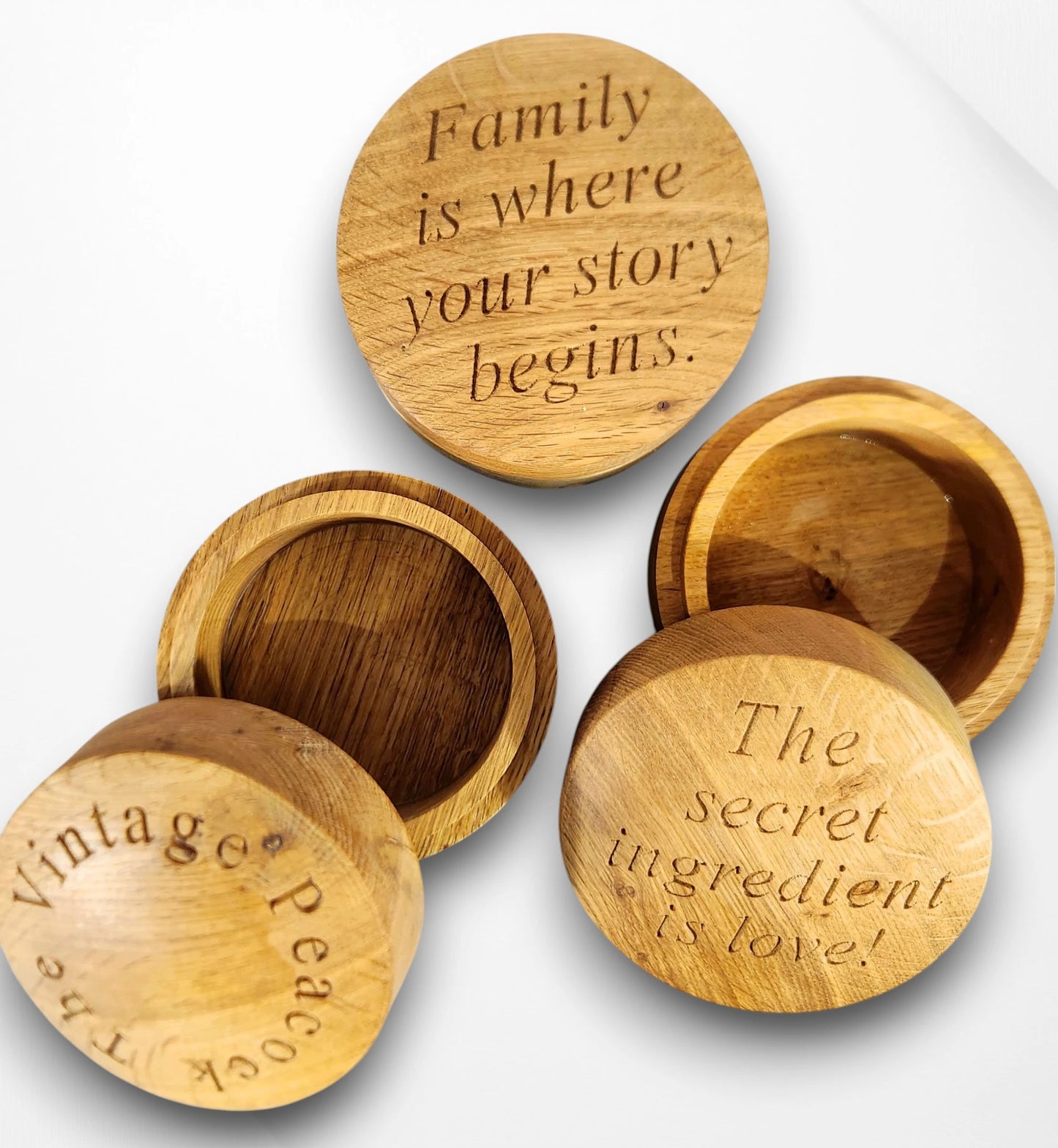 Set of handcrafted round oak trinket boxes engraved with heartfelt quotes — “Family is where your story begins” and “The secret ingredient is love,” perfect personalised wooden keepsake gifts for home or family occasions.