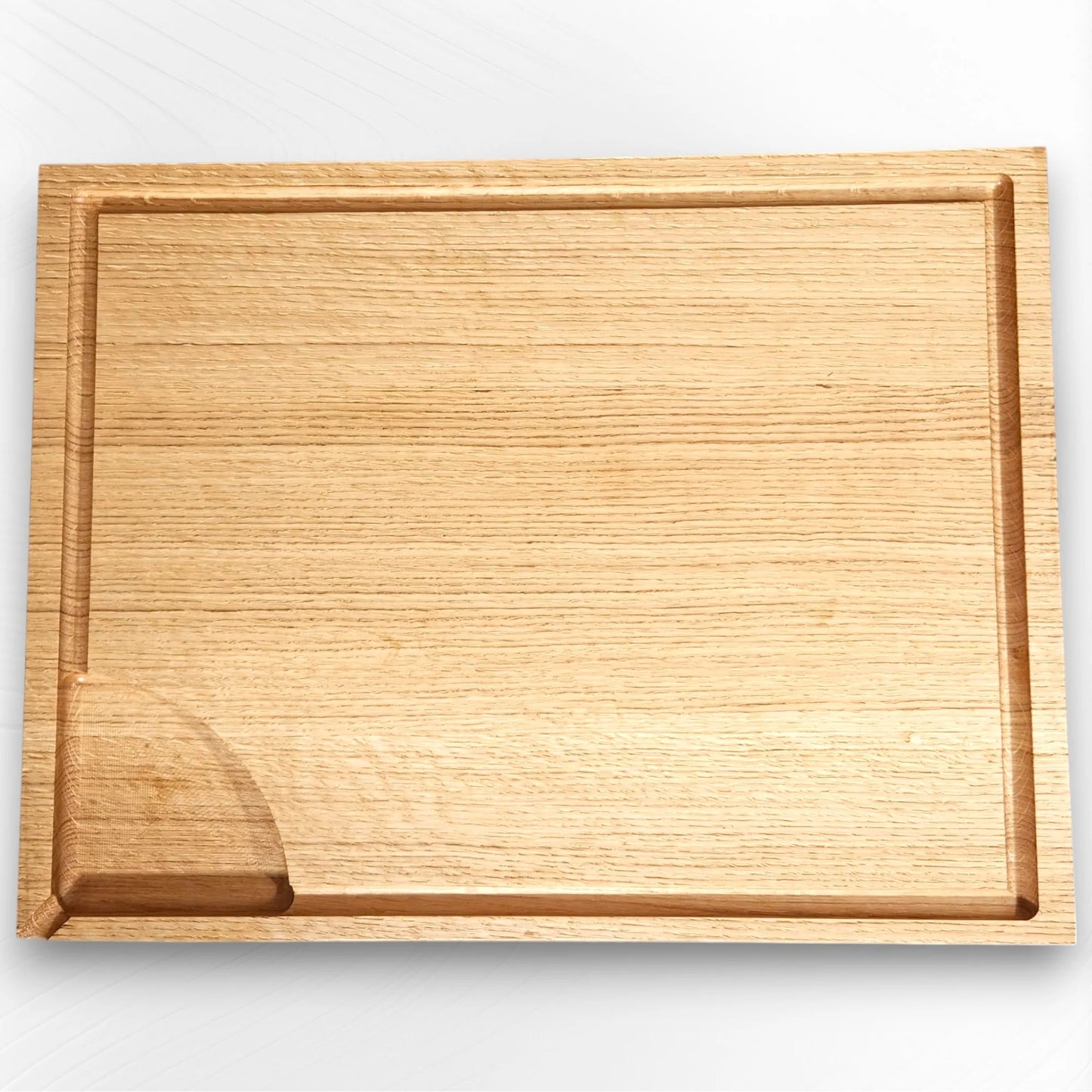 Top-down view of solid oak handmade oak chopping board with juice groove and utensil rest, showing natural wood grain. Premium wooden board by The Crafty Oak.