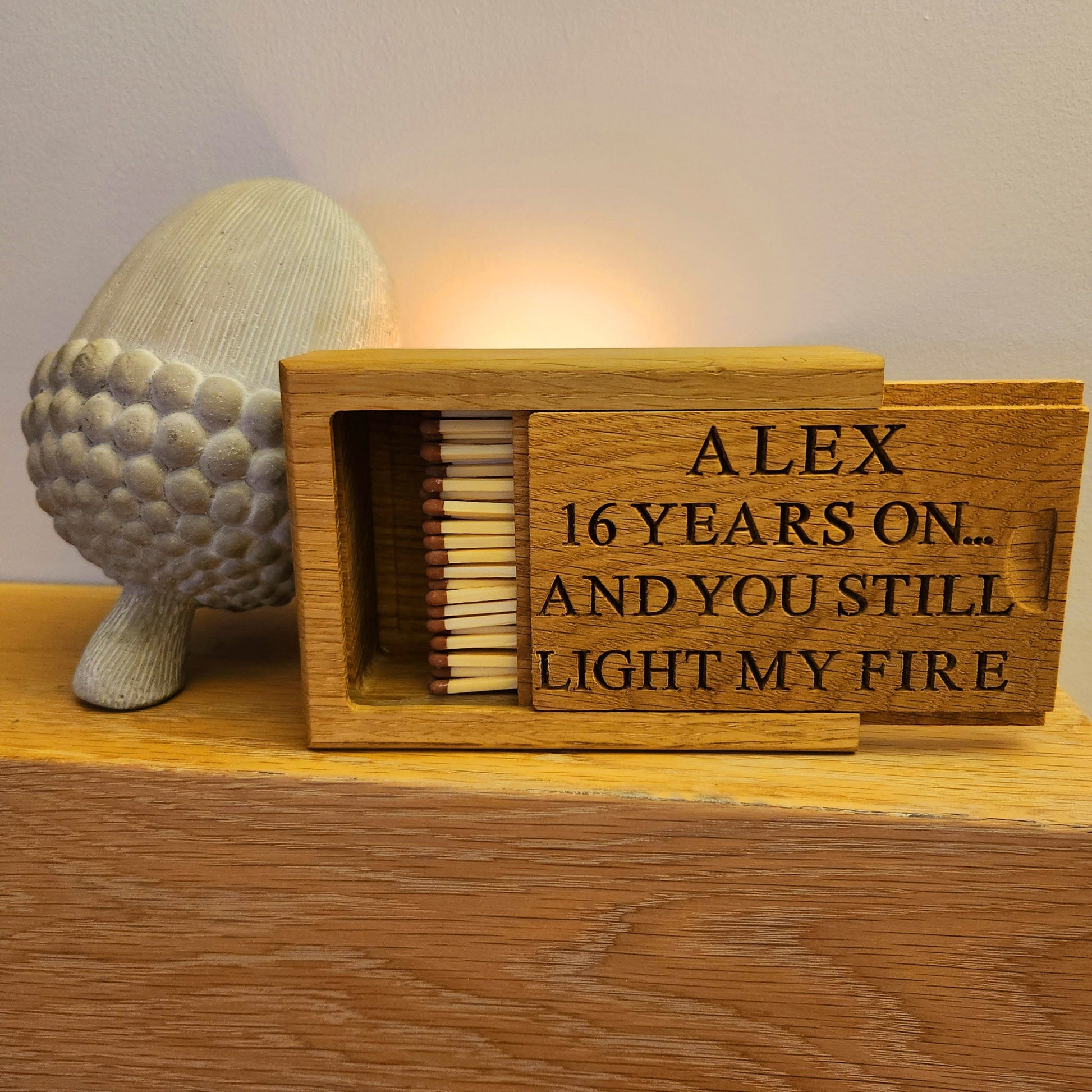 Wooden matchbox with engraved text on a wooden surface