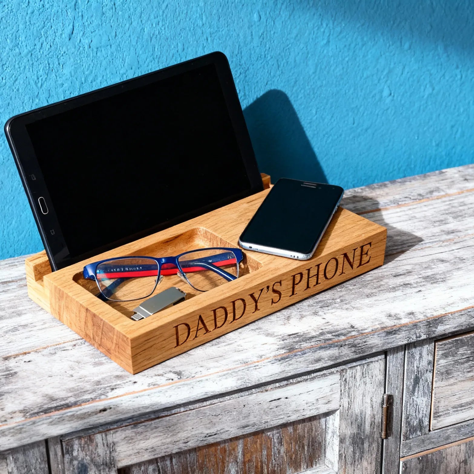 Wooden tray with 'DADDY'S PHONE' engraving, holding a tablet, phone, and glasses on a wooden surface. Ideal gift for Dad or men