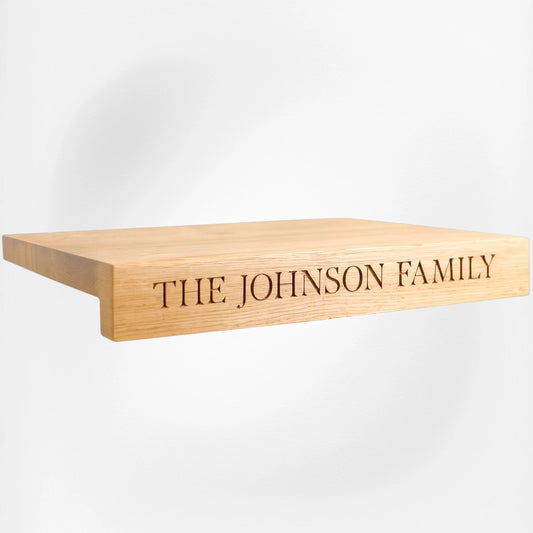 Customized wooden oak carving board with the words "The Johnson Family" carved into wood.