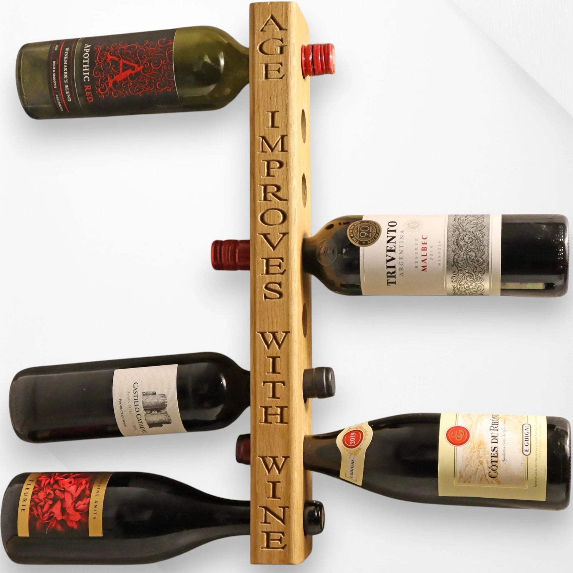 Wall-mounted oak wine rack holding eight bottles, handmade from solid wood, displayed on a white wall in a modern kitchen.
