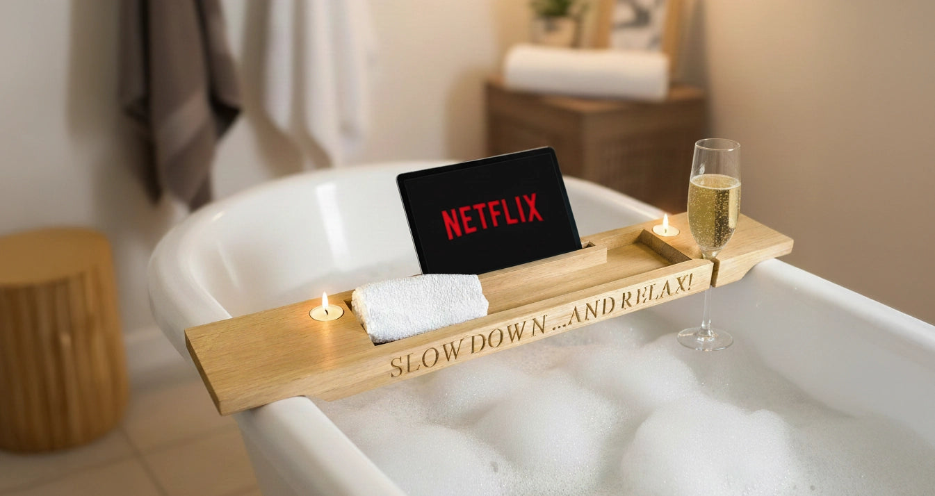 Personalised oak bath bridge with engraved message “Slow down... and relax!”, holding a glass of wine, tablet, and candle — handmade luxury gift for her to unwind at home