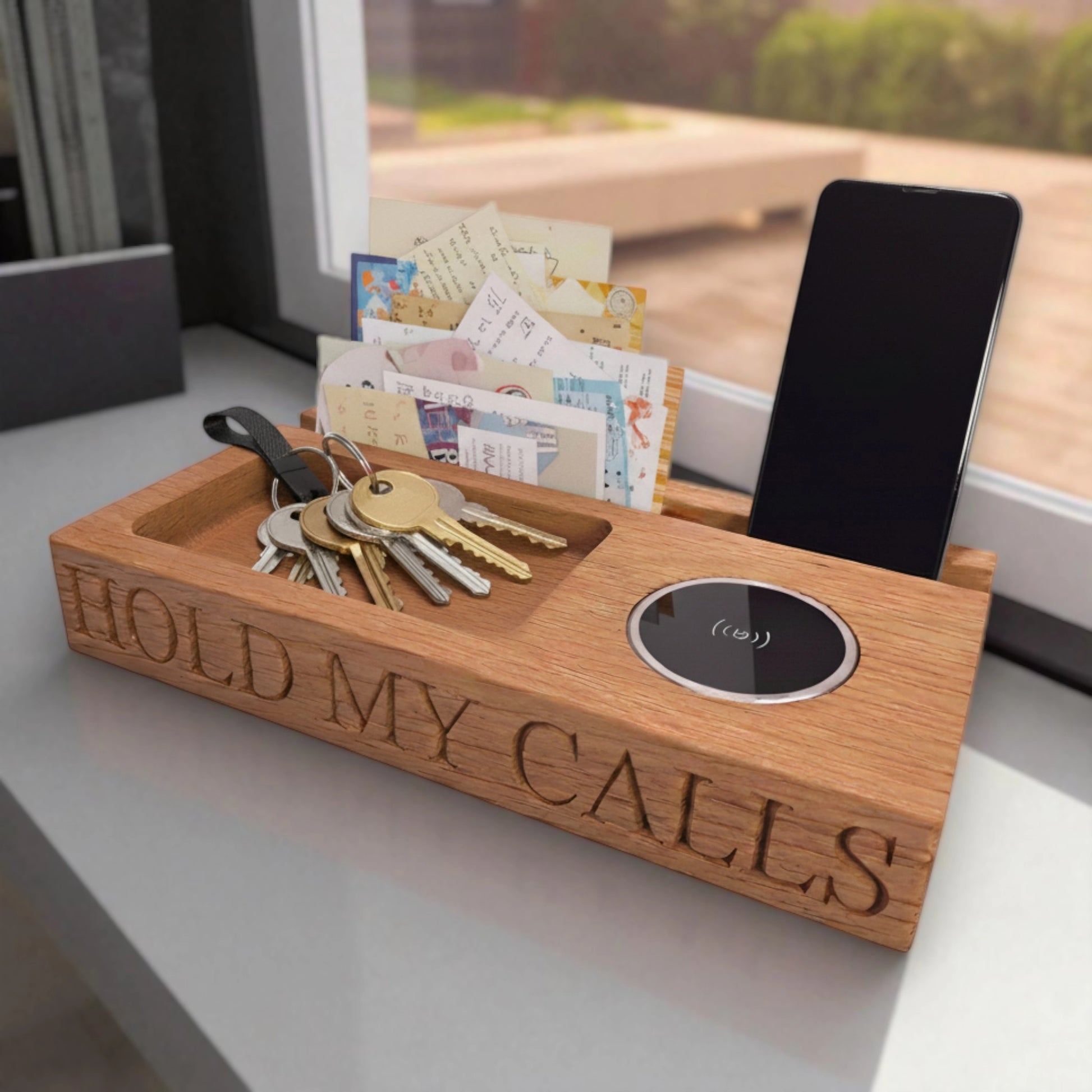 Engraved oak wireless charging tray with the phrase ‘Hold My Calls,’ featuring phone stand, key holder, and letter organiser—handmade wooden desk and bedside organiser by The Crafty Oak.