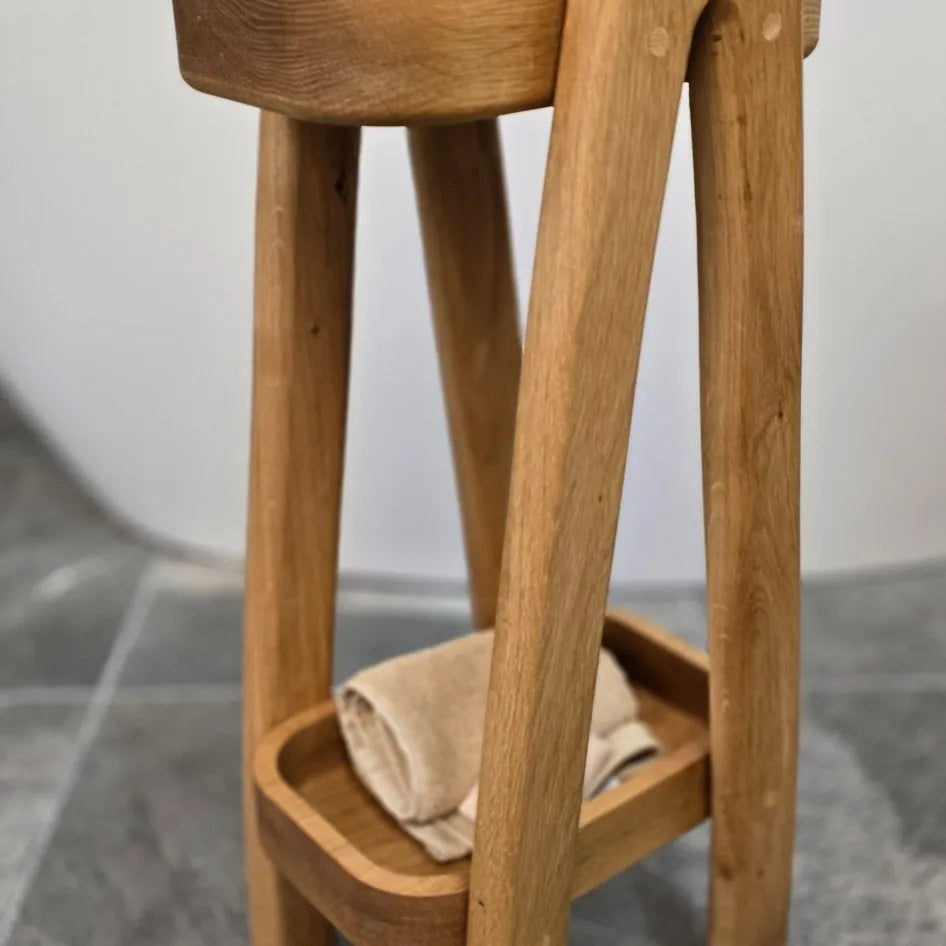Close-up of lower shelf on handmade oak bath caddy, holding a rolled towel. Premium wooden bathroom organiser by The Crafty Oak.