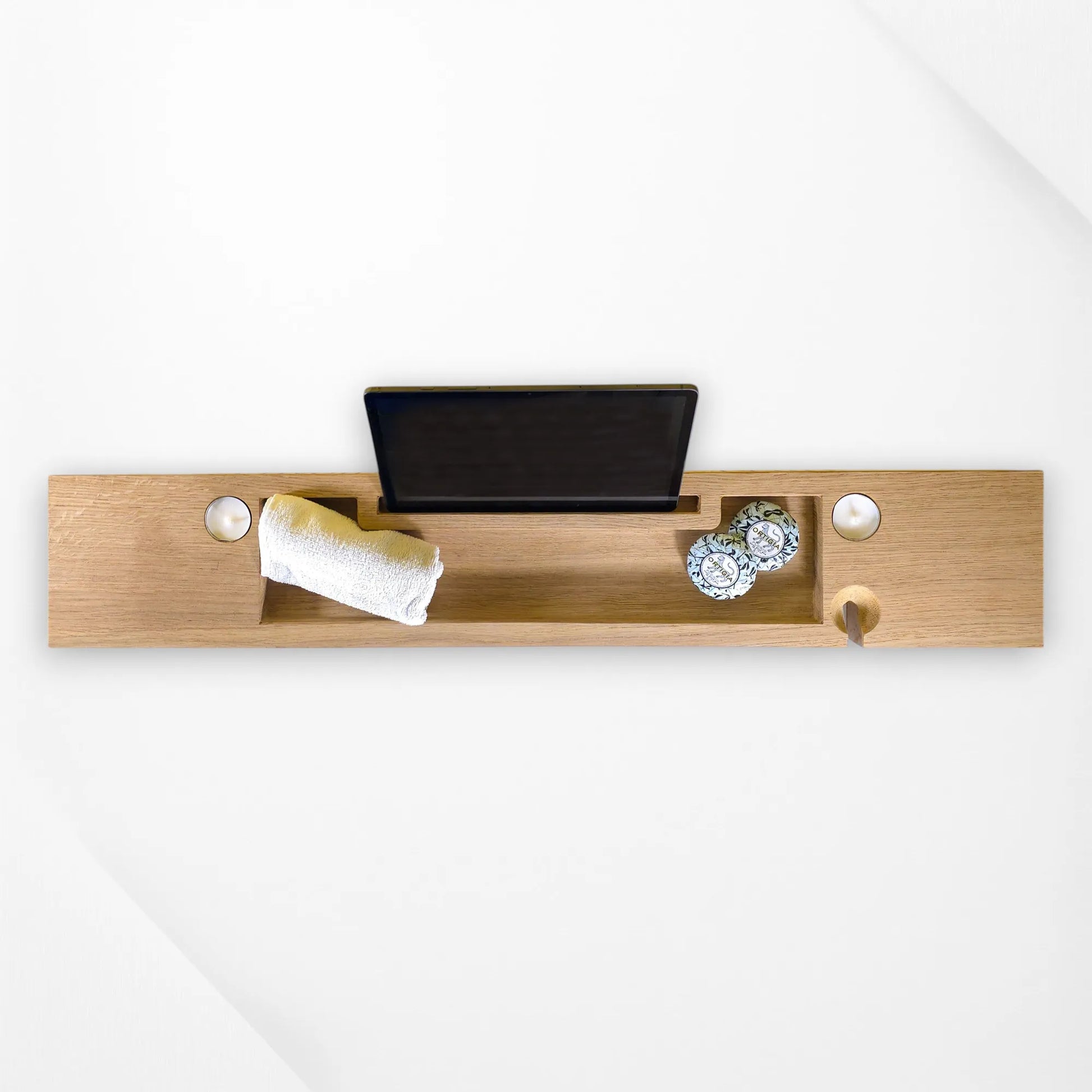 Top-down shot of oak bath tray with slots for wine, tablet, towel and candles—luxury wooden tray.