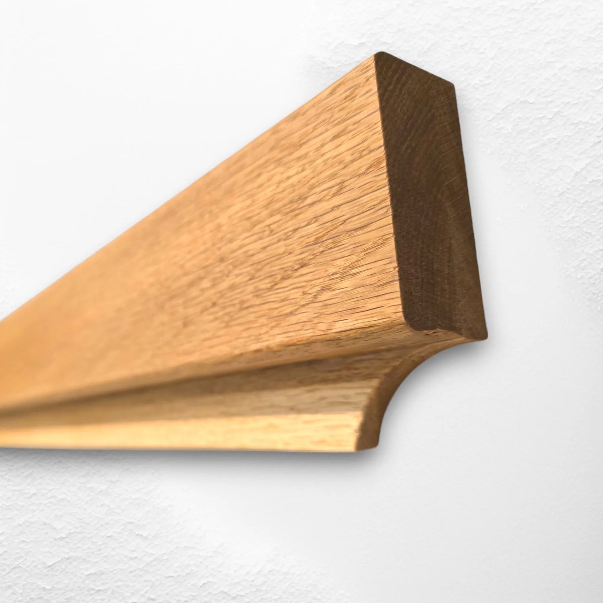 Close-up angled view of oak Gravity Track, showing smooth wood grain and minimalist design. Handmade wooden photo and paper holder by The Crafty Oak.
