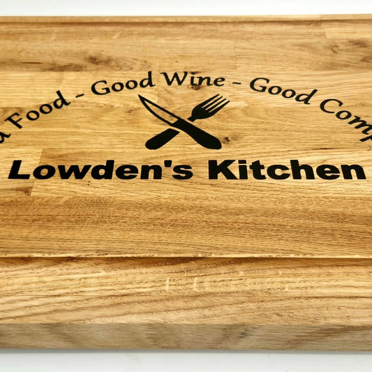Wooden cutting board with engraved text and logo, featuring customized 'Lowden's Kitchen'.