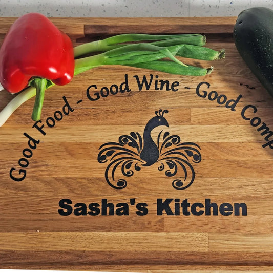 Personalized cutting board with 'Sasha's Kitchen' logo and vegetables on a wooden surface