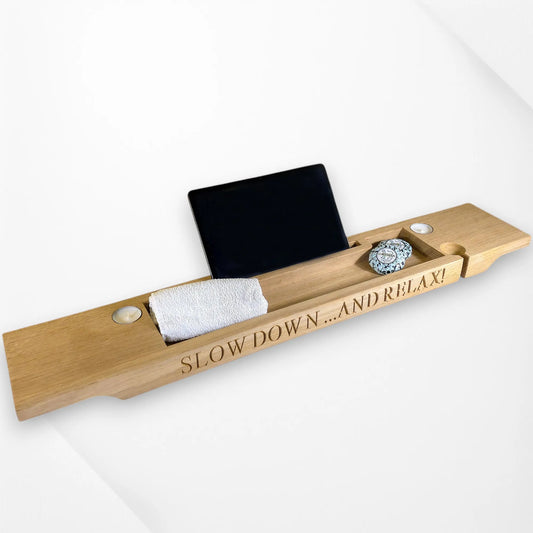 Oak bath tray holding wine glass, tablet, candle and towel slots—elegant wooden bath rack design.
